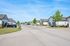 Charming suburban neighborhood with modern homes, lush greenery, and a clear blue sky, perfect for families.