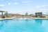 Inviting outdoor pool area with vibrant yellow lounge chairs and a stylish pergola, perfect for relaxation and socializing.
