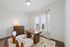 Bright and inviting home office with large windows, modern wooden desk, and stylish chairs, bathed in natural light.