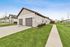 Charming suburban homes with beautiful manicured lawns and spacious driveways under a clear blue sky.