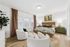 Elegant bedroom with a luxurious king-sized bed, stylish decor, and cozy seating area, featuring soft natural light and inviting ambiance.