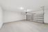 Spacious and well-lit garage with a modern automatic door, offering ample space for vehicles and storage.