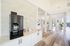 Bright and inviting open-concept community space with sleek coffee station and elegant wood flooring.