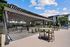 Spacious outdoor patio featuring a stylish pergola, modern barbecue grills, and comfortable seating in a vibrant apartment community.
