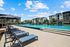 Luxurious apartment complex showcasing a stunning swimming pool, modern lounges, and vibrant outdoor space under a clear blue sky.