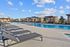 Luxurious poolside oasis with sleek lounge chairs, modern cabanas, and a sparkling blue swimming pool under a sunny sky.