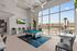 Modern entertainment area featuring a sleek pool table, stylish seating, and expansive windows offering natural light and scenic outdoor views.