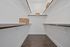 Spacious walk-in closet with elegant shelving and stylish flooring, perfect for organized storage.