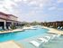 Luxurious outdoor swimming pool area with modern lounge chairs, surrounded by elegant architecture and lush greenery, offering a resort-style living experience.