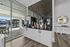 Modern apartment amenities featuring a sleek coffee station with a black marble backsplash and a view of a stylish outdoor seating area.