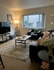 Inviting living room with modern decor, featuring a plush rug, sleek furniture, and warm lighting.