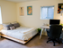 Bright, modern bedroom with a cozy bed, sleek desk space, and artistic wall decor.