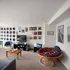 Charming living room with vintage vinyl wall art and eclectic decor, featuring cozy seating and a modern entertainment center.