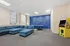 Inviting clubroom with modern blue sectional sofa, ping pong table, and retro arcade game for entertainment.