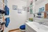 Charming bathroom with vibrant blue accents and artistic floral wall decor, creating a modern yet cozy ambiance.