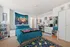Vibrant bedroom featuring cozy blue bedding, artistic tapestry, chic makeup vanity, and a colorful rug, offering a creative and inviting personal space right by Pitt and Carnegie Mellon college campus