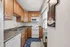Charming kitchen with warm wooden cabinets, sleek granite countertops, and modern appliances in a cozy apartment setting for Pitt and Carnegie Mellon students