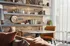 Elegant living space with tasteful wood shelves, chic decor, and a cozy round table for a welcoming ambiance.