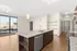Chic open-plan kitchen and living area boasting modern finishes, large windows, and elegant lighting fixtures.