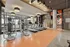 Contemporary gym space featuring state-of-the-art treadmills and elliptical machines with large windows and stylish lighting.