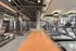 Modern apartment fitness center with sleek treadmill lineup, state-of-the-art exercise machines, and stylish industrial decor.