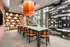 Sleek lounge area with modern decor featuring a long table and vibrant orange chandelier, perfect for entertaining.