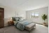 Bright and inviting bedroom featuring a plush bed with elegant linens, accented by modern nightstands and a leafy plant near a sunlit window.