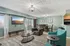 Chic open-concept living and dining area with modern lighting, cozy seating, and a wall-mounted flat-screen TV.