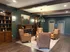 Elegant lounge area with plush armchairs and stylish wooden bookshelves, perfect for relaxation and ambiance.