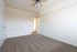 Bright and inviting bedroom featuring fresh carpeting, a ceiling fan, and ample natural light.