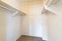 Spacious walk-in closet with ample shelving and neutral tones, perfect for organized storage.