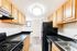 Modern kitchen with sleek black countertops, light wood cabinetry, and contemporary appliances offering a stylish cooking space.