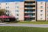 Charming apartment complex with a welcoming entrance, featuring a red awning and well-maintained landscaping.
