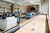 Modern lounge area with comfortable seating, stylish decor, and board games, featuring a shuffleboard table for entertainment.