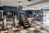 Modern gym facility with state-of-the-art exercise equipment, including ellipticals, a Jacob's Ladder, and a comprehensive weightlifting setup.