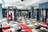 Modern apartment gym with state-of-the-art equipment, vibrant red benches, and spacious workout areas.