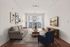 Modern living room with large windows, elegant sofa, stylish artwork, and chic decor, ideal for relaxation and entertainment.
