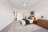 Elegant bedroom with modern decor, featuring a cozy bed, wooden furniture, and a stylish patterned rug, perfect for a serene retreat.