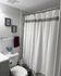 Contemporary bathroom featuring elegant white shower curtain and modern decor.