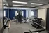 Modern apartment fitness center with state-of-the-art equipment, free weights, and large mirrors, ideal for a convenient workout.