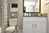 Sophisticated bathroom featuring a granite countertop, stylish mirror, and classic white cabinetry.