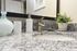 Modern bathroom vanity with granite countertop, sleek faucet, and decorative plant.