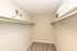 Bright walk-in closet with dual shelving and storage baskets.