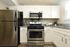 Modern kitchen featuring stainless steel appliances, white cabinets, and granite countertops.