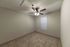 Inviting bedroom with plush carpet flooring, ceiling fan, and natural light from window blinds.
