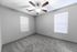 Inviting bedroom with carpeted floor, ceiling fan, and natural lighting from two windows.
