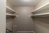 A roomy walk-in closet with multiple shelves and clothing rods, offering ample storage space.