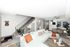 Stylish open-plan living room with white sectional sofa and dining area.