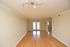 Bright and spacious living room with elegant wooden flooring and modern ceiling lights.