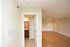 Bright apartment hallway leading to an inviting living room with hardwood floors.